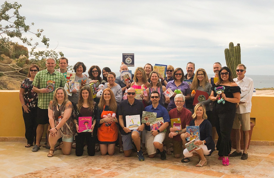 Group photo of LGC personnel holding various books and toys
